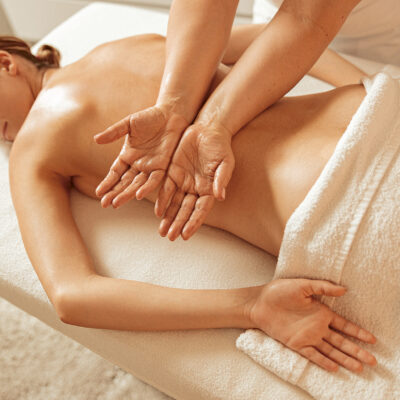 Charming woman receiving therapeutic back massage in spa salon Eine Frau wird am Rücken massiert